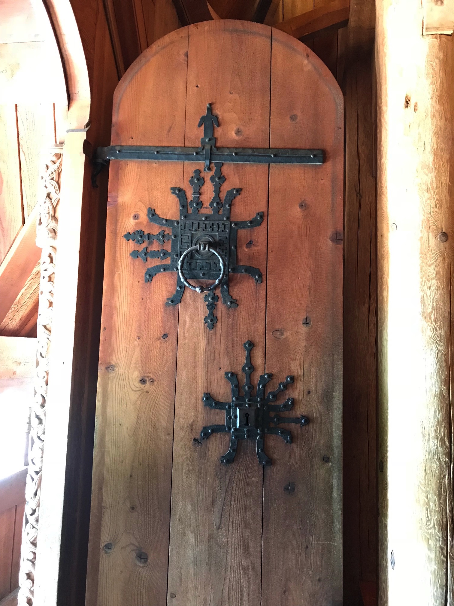 A wooden, church door with ornate, wrought iron knockers
