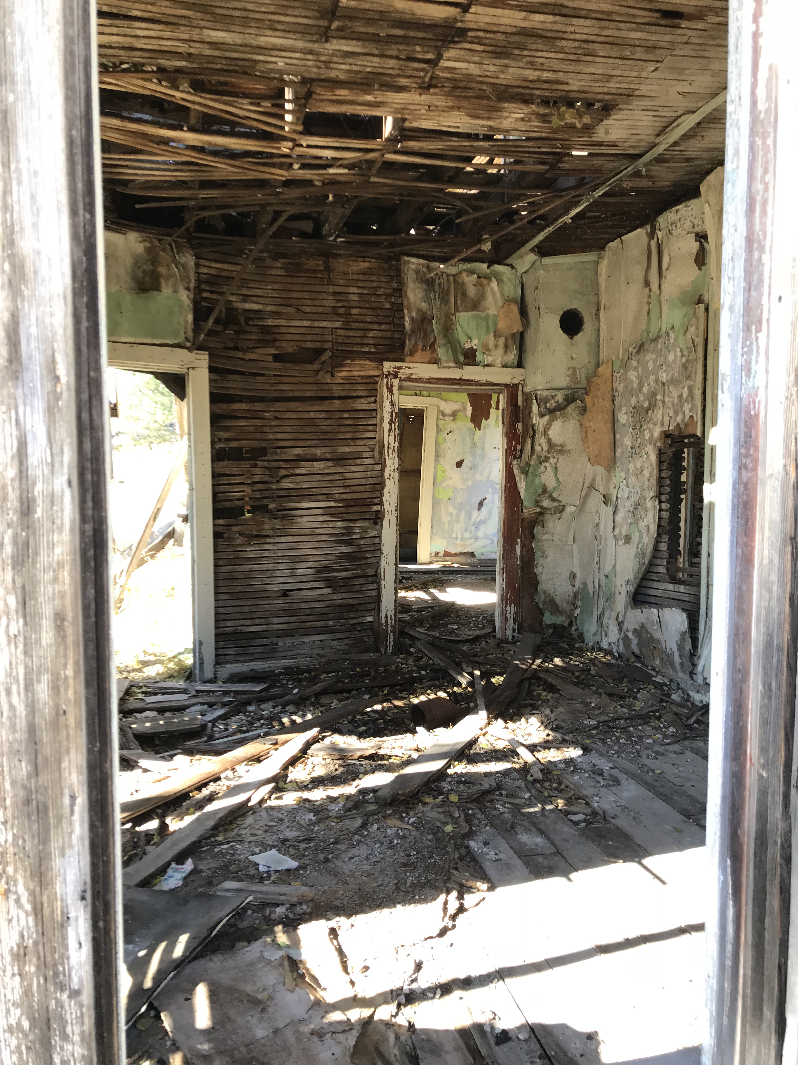 Inside the room of an old house. No doors or windows are left and the frame is visible on the floor/walls/ceiling 